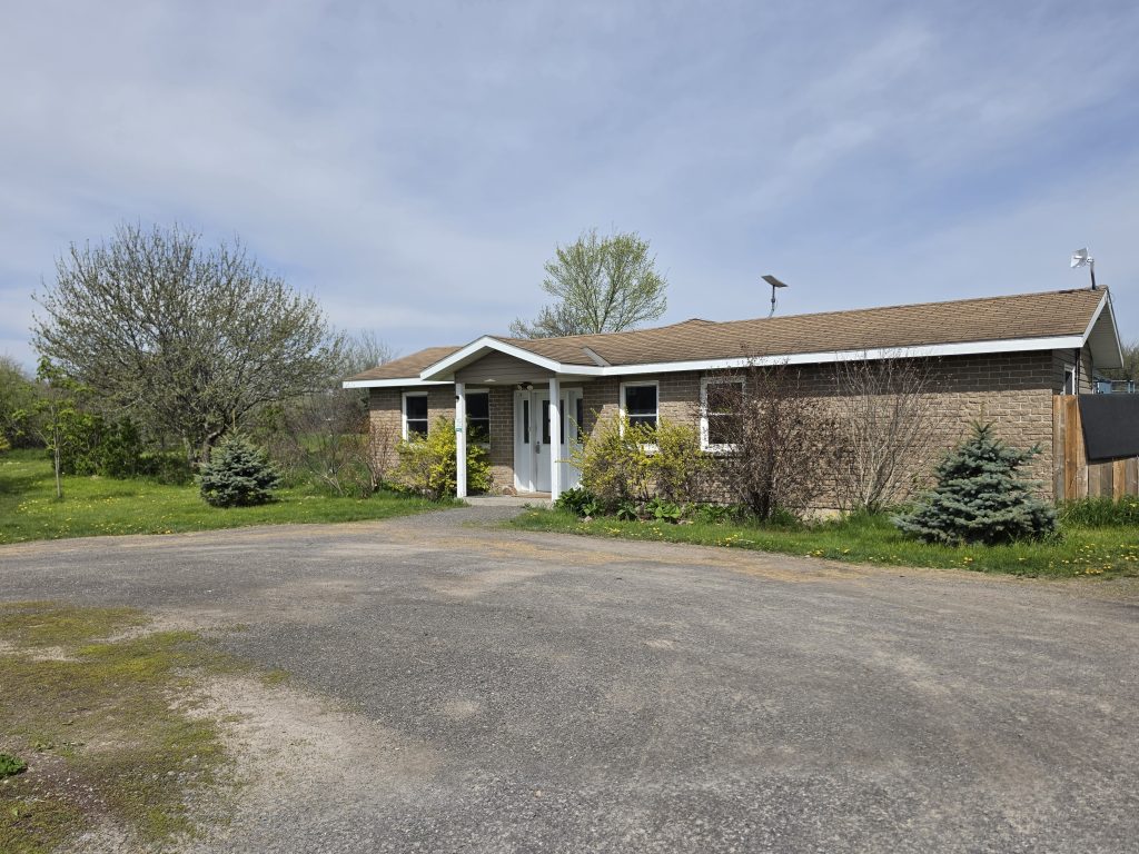 Exterior of Loyalist Barkway Boarding Kennels in Bath Ontario — a working rural kennel facility in spring